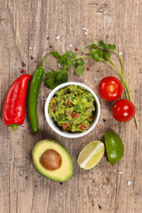 Obraz na płótnie Canvas Guacamole with avocado, lime, tomato and cilantro