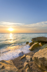 waves lapping on the beach of small pebbles at sunset