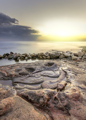 the bright sun at sunset, illuminating the stone snake