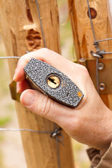 Robotnik zamyka bramę na kłódke kluczem © Mirek