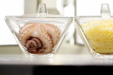 raw fresh octopus and boiled potatoes inside elegant glass bowl