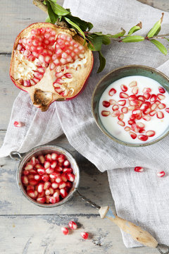 pomegranate with vintage strainer full of grains and  yogurt