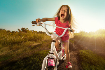 Portrait of happy funny girl on bicycle