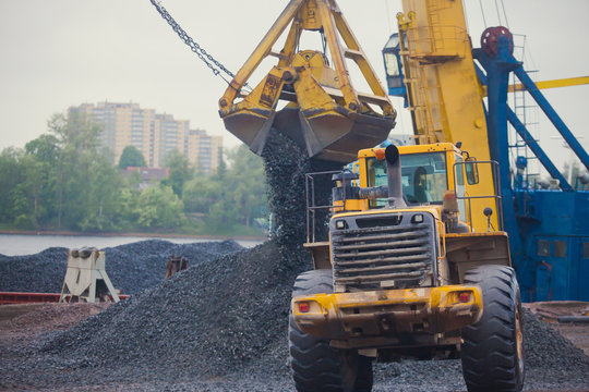 Yellow Heavy Excavator And Bulldozer Unloading Road Metal During