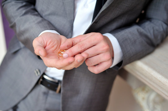 groom holding a gold rings