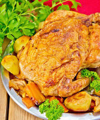 Chicken baked with vegetables in dish on board