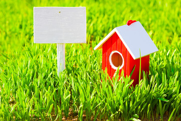 Red house and signboard on grass