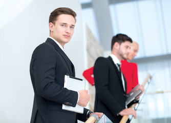 Portrait of motivated and handsome businessman with collegues on