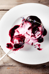 Berry ice cream with topping on a white plate