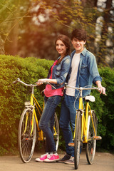 Obraz premium Young couple with bicycles in park