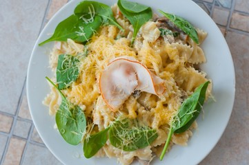 Farfalle pasta with ham, mushrooms, fresh spinach and cheese