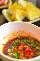 Spicy dipping sauce with dumpling background