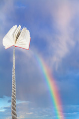 book tied on cord soars into sky with rainbow