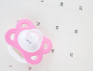 Pregnancy concept delivery due date with calendar and pacifier