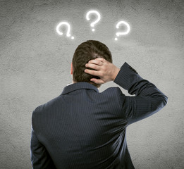 Businessman thinking of problem solution with quest marks over