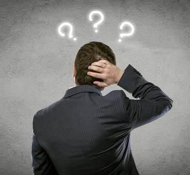 Businessman thinking of problem solution with quest marks over