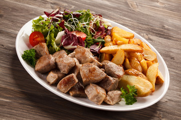 Grilled meat with baked potatoes and vegetables