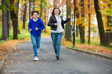 Obraz premium Girl and boy running, jumping in park