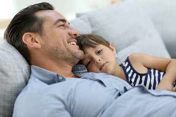 Fototapeta na wymiar Daddy with little girl relaxing in sofa