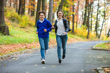 Girl and boy running, jumping in park