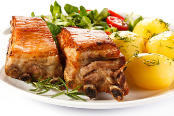 Tasty grilled ribs with vegetables on white background