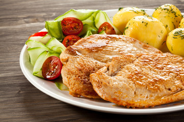 Fried pork chop, boiled potatoes and vegetable salad