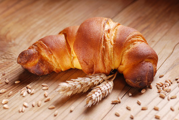 brioche con spighe di grano sul tavolo di legno