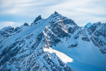 Snowy blue mountains in clouds