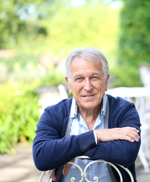 Portrait Of Senior Man Sitting In Home Garden