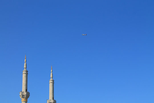 plane in the sky against a background of minarets