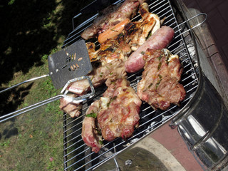 Barbecued steak and sausages on the grill