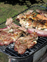 Barbecued steak and sausages on the grill