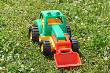 Obraz premium Toy green tractor on the grass.