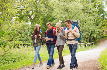 group of smiling friends with backpacks hiking