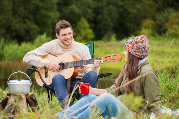 smiling couple with guitar in camping