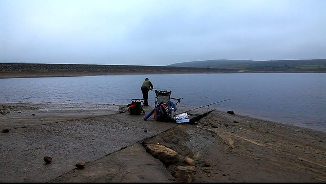 man fishing at reservoir uk