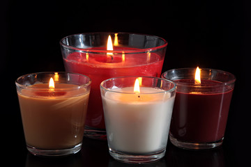 Four of burning candles in glass candle holders