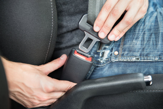 Man Fastening Seat Belt In Car