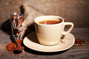 Cup of tasty rooibos tea, on wooden table