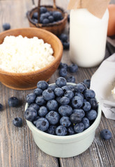 Fresh blueberries and milk products on wooden table