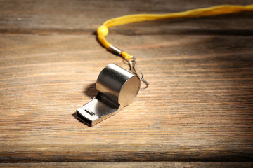 Sport metal whistle on wooden background