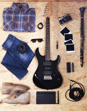 Musical equipment, clothes and footwear on wooden background