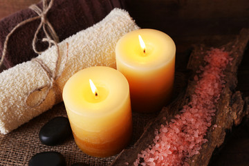 Obraz na płótnie Canvas Spa stones with candles and sea salt on wooden background