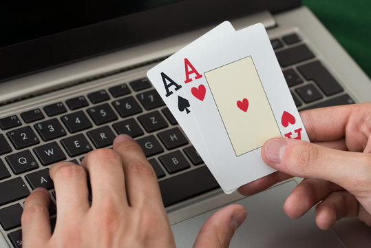 Businessman Holding Cards While Using Laptop