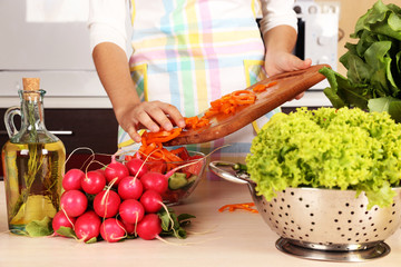 Woman cooking vegetable salad in kitchen