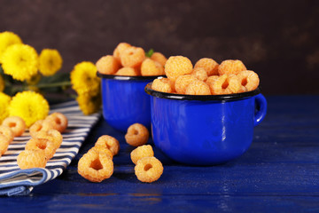 Yellow raspberries in dark blue mugs with wildflowers and