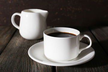 Cup of coffee and cream in milk jug