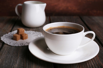 Cup of coffee with cream in milk jug and sugar cubes