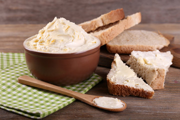 Fresh homemade butter in bowl and sliced bread,