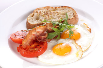 Freid eggs with tomatoes and becon.